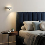 Biała lampa ścienna skierowana na łóżko na białej ścianie.