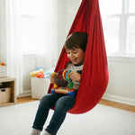 Czerwona sensoryczna huśtawka – użycie przez małego chłopca